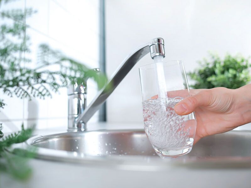 Wasserglas unter fließendem Leitungswasser, Symbol für die zuverlässige Wasserversorgung durch ErmstalWasser